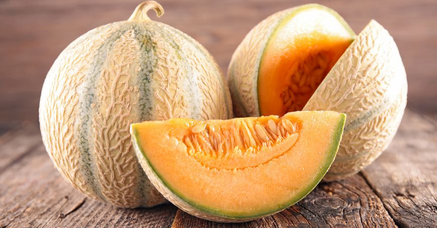 due meloni, di cui uno aperto con spicchio poggiati su untavolo, un frutto buono e ricco di vitamine ma che ha delle controindicazioni per la colite