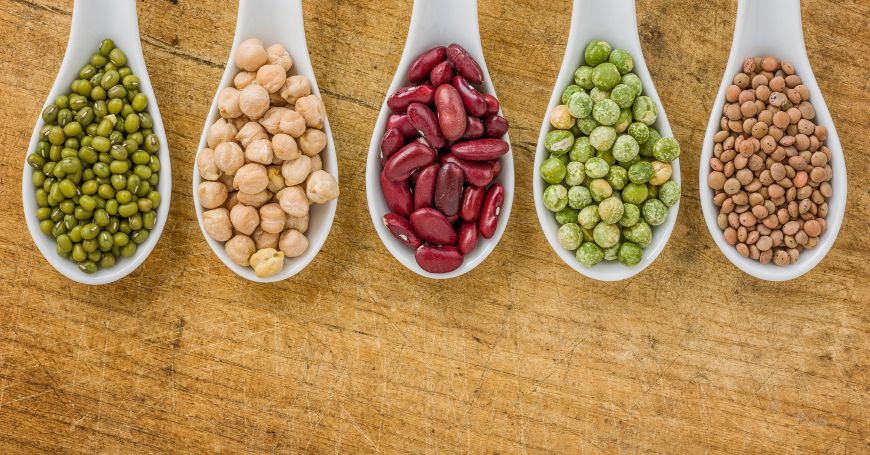 cucchiai con legumi su un tavolo esempio di alimenti da evitare con la colite e colon irritabile