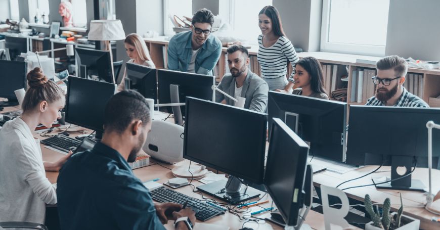 Gruppo di colleghi che lavorano in open space mentre affrontano sfide legate alla colite al lavoro